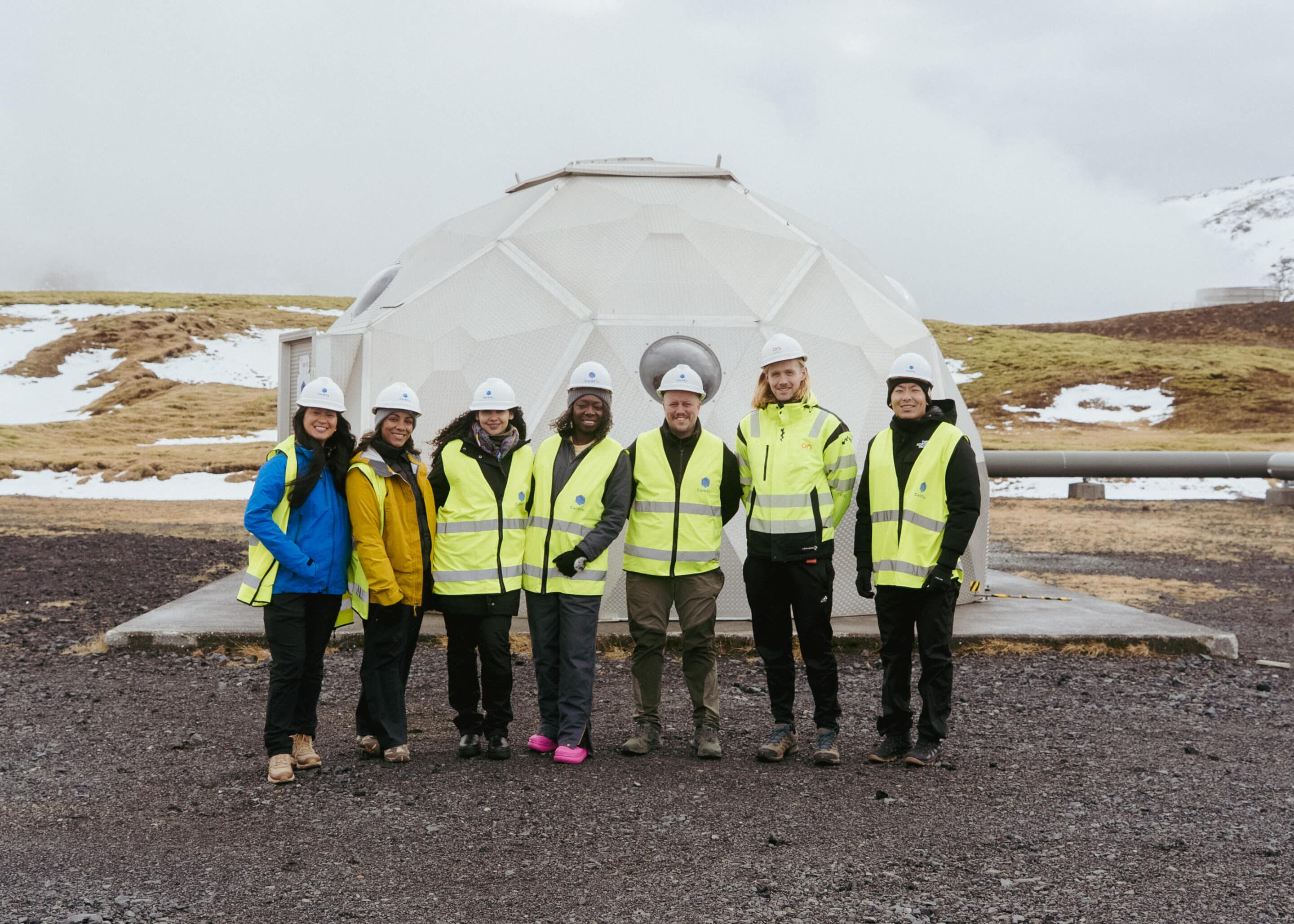 ELUME Geothermal Energy Facility Visit Professionals in protective vests and helmets in front of a geothermal borehole and injection well